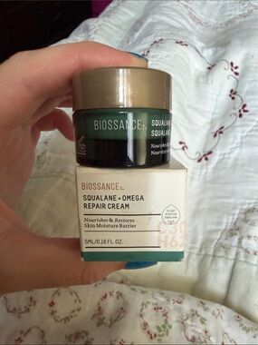 Biossance moisturizer jar in green with gold lid